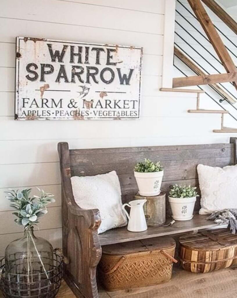 entryway with old antique church pew bench white pillows flower pots greenery antique sign shiplap wall