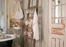 antique clawfoot tub in shabby country chic bathroom with ladder for towels and soaps chippy paint bard doors and crystal chandelier