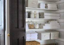 organized linen bathroom closet with folded towels and linens weaved baskets and totes