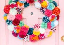 colorful pom pom wreath on pink door