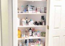 corner closet in bathroom with white shelves and full of toiletries