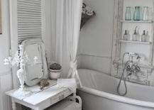 clawfoot antique tub in country chic bathroom with white shutter chandelier crystal vanity with mirror and old architecture turned shelving