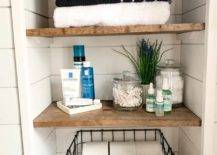 Close up of farmhouse style closet with folded black and white towels toiletries and wire basket