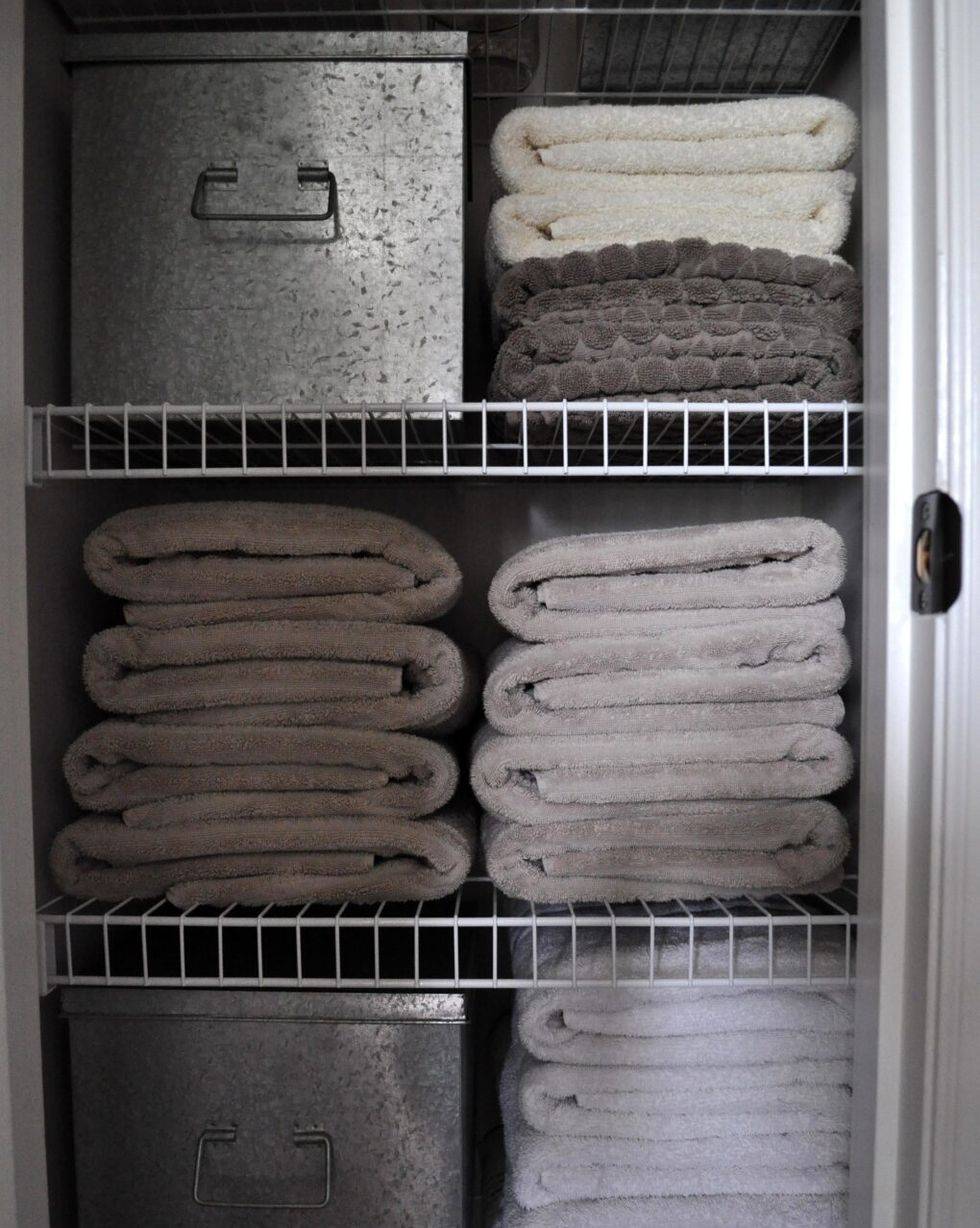 folded grey towels on wire shelving close up bathroom closet
