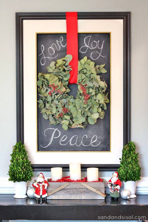 framed christmas wreath with red ribbon on chalkboard framed