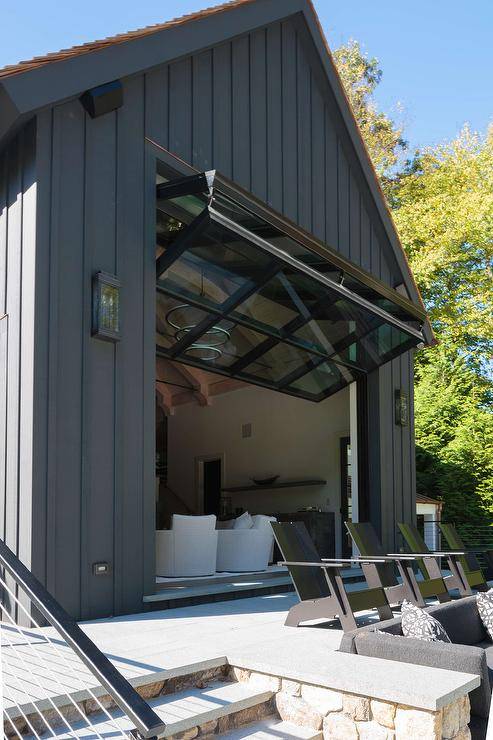 Gorgeous black pool house is finished with a glass garage style door.