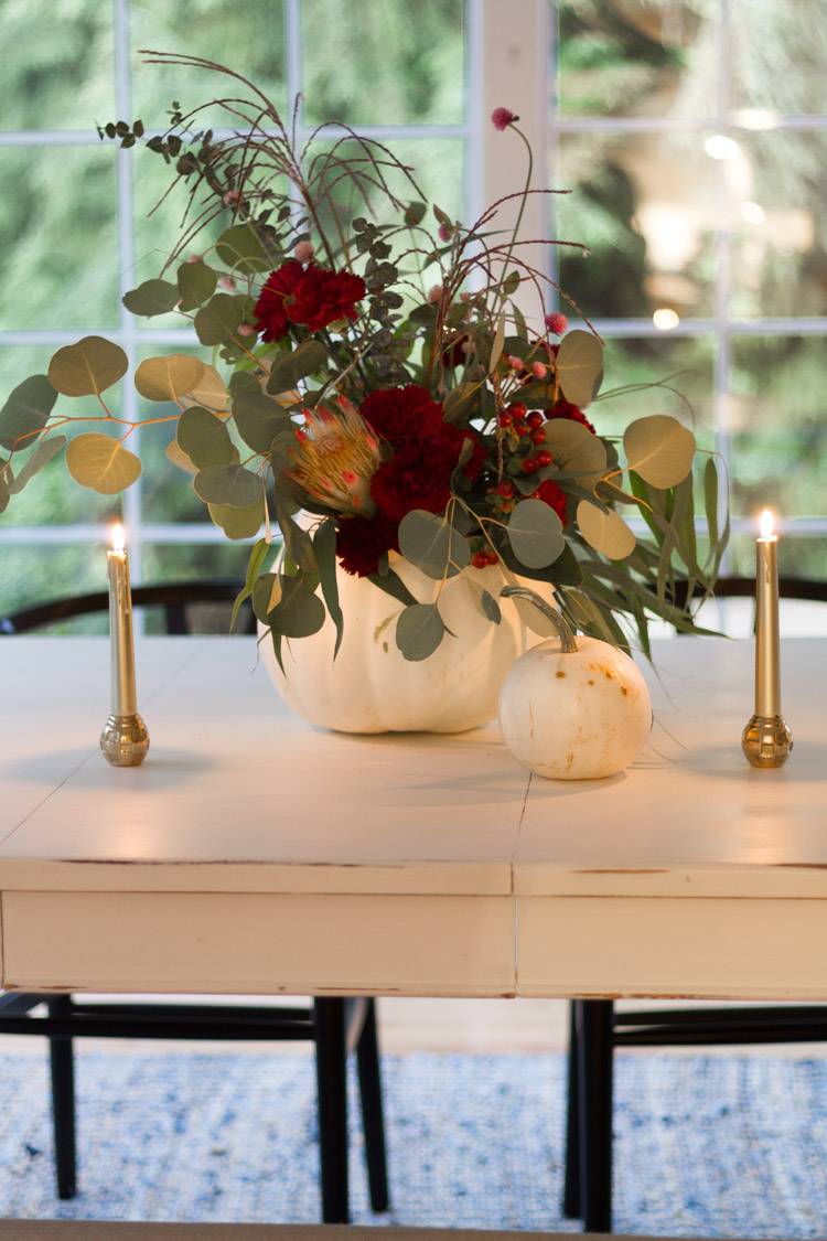 A dining table set with Thanksgiving flowers