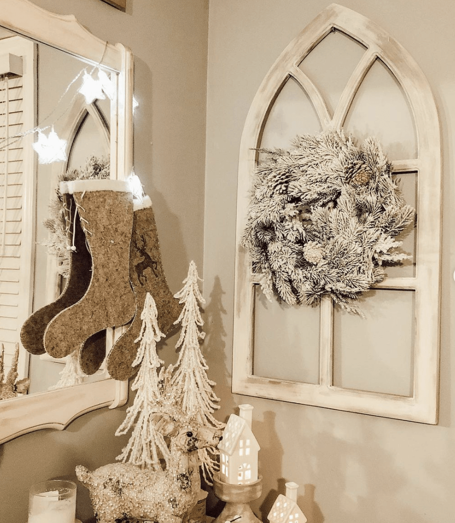 white flocked wreath hanging on arch window frame