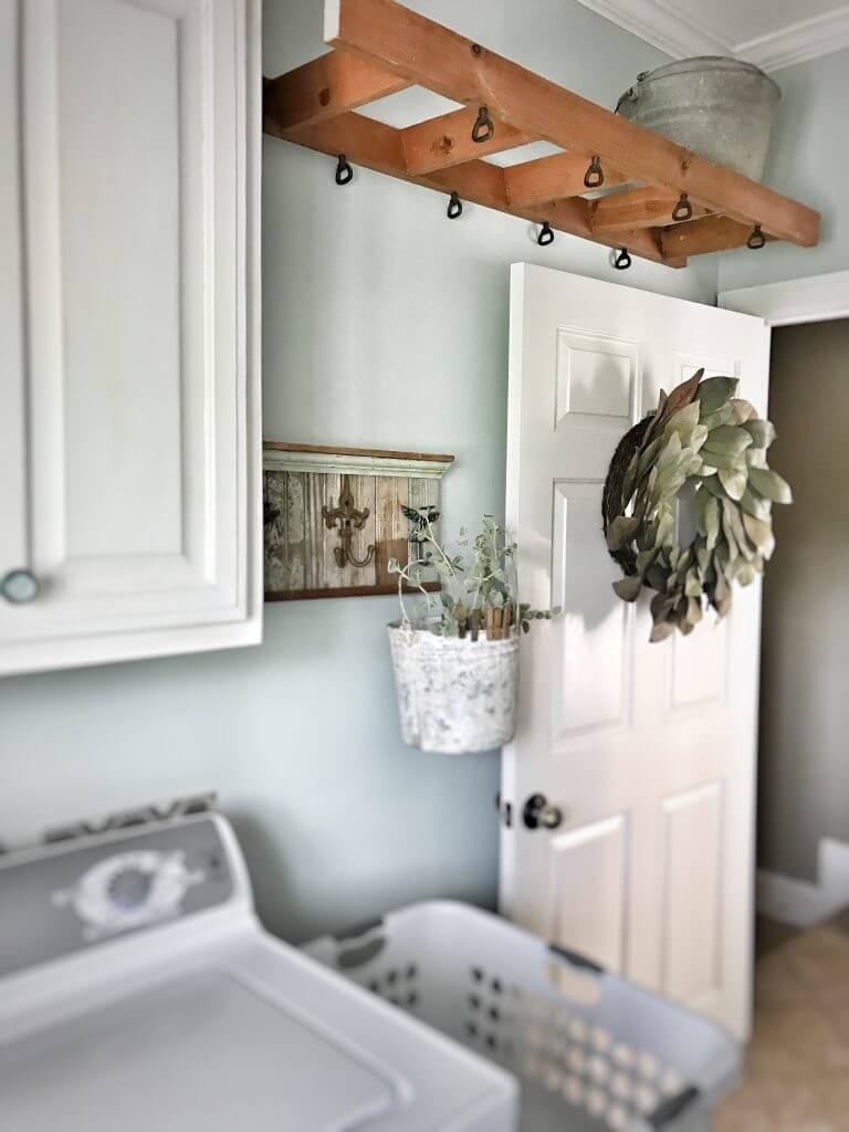 ladder hanging from ceiling in laundry room magnolia wreath hanging on door washer and laundry basket