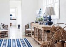 Brown and blue cottage foyer design features navy blue double gourd lamps with blue stripe lamp shades on a brown oak spindle console table with Chinese ginger jars and a blue stripe rug.