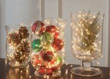 large hurricane jars with christmas lights pinecones and ornaments
