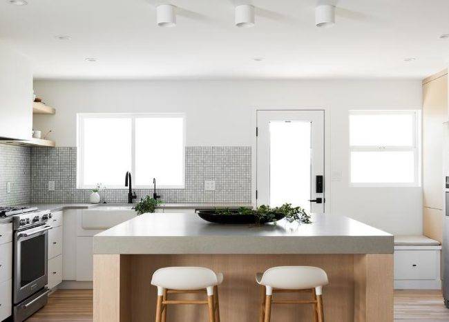 Minimal white and rift sawn oak cabinet kitchen with extra thick concrete countertops.