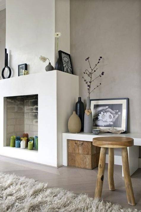 a modern non-working fireplace with colorful candles inside looks bold and fun and sticks to the style of the room
