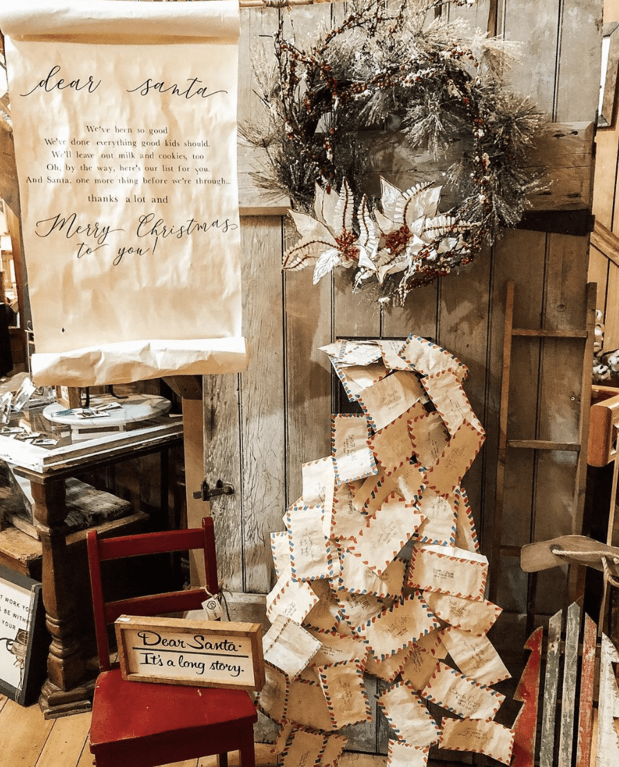 old vintage door with wreath hanging on it letters to santa pouring out of mailbox christmas store display