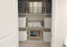organized linen bathroom closet with wire baskets and plastic totes paper towel toilet paper