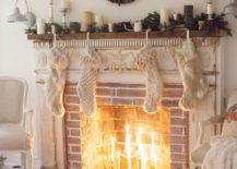 fireplace with brick and mantle candlesticks in middle with greenery and white pillar candles on top