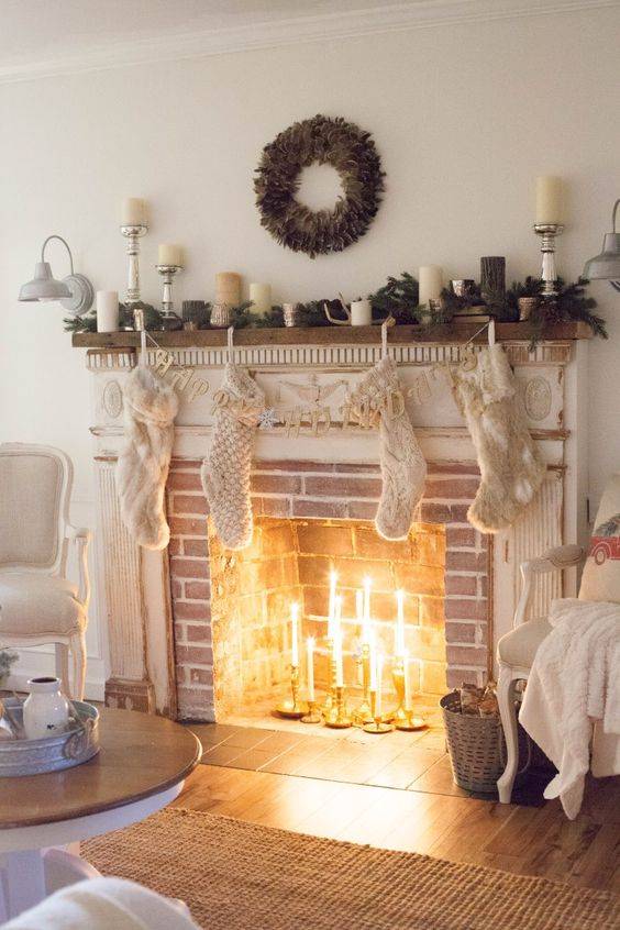 fireplace with brick and mantle candlesticks in middle with greenery and white pillar candles on top