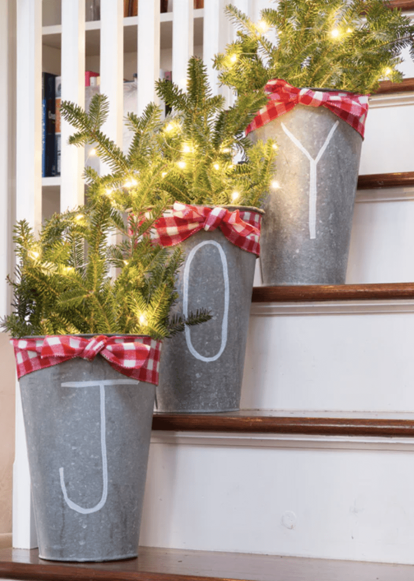 light up greenery in buckets joy on stairs