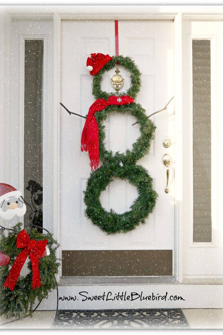 snowman wreath made out of evergreen hanging on white door
