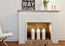 a non-working fireplace with bricks inside and out and pillar candles for styling it right
