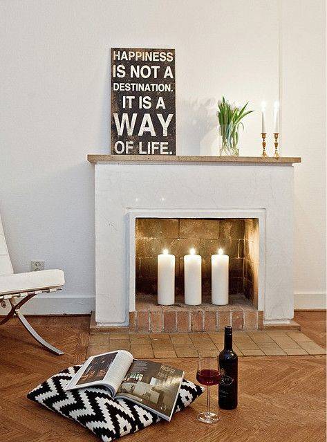 a non-working fireplace with bricks inside and out and pillar candles for styling it right