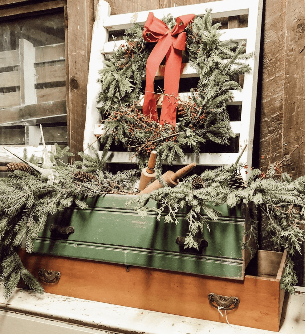 vintage display with evergreen christmas wreath and old drawers