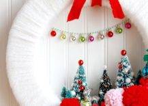 white yarn wrapped wreath with retro decorations red ribbon pom poms and bottle brush trees
