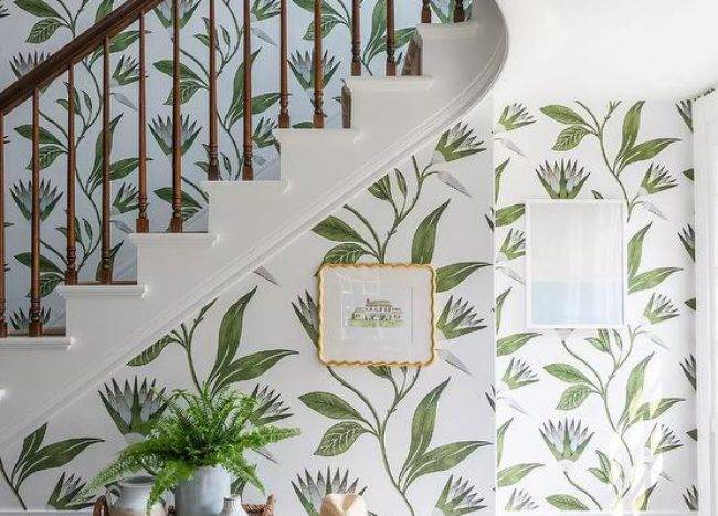 Anna French Savoy Cleo Vine Wallpaper covers a staircase wall positioned behind an ivory linen bench.