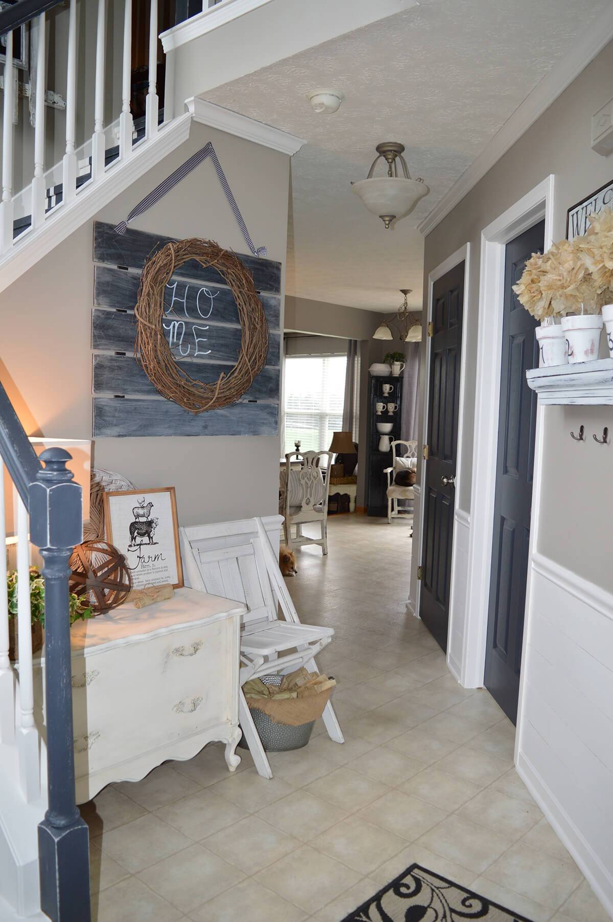 entryway hallway with country chic decorated style old antique dresser chalkboard art with grapevine wreath white folding chair staircase chalkpainted