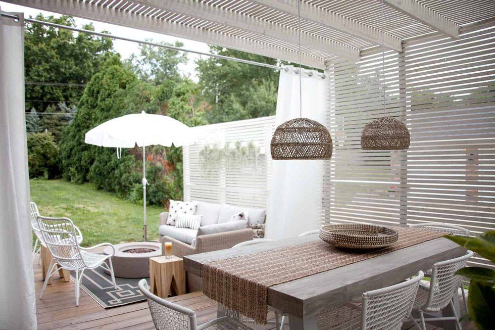 white wood thin strip pergola with hanging pendants white umbrella wood table outdoor dining area