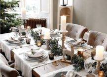 a chic winter tablescape with white runners, a dried eucalyptus runner, deer figurines, pillar candles