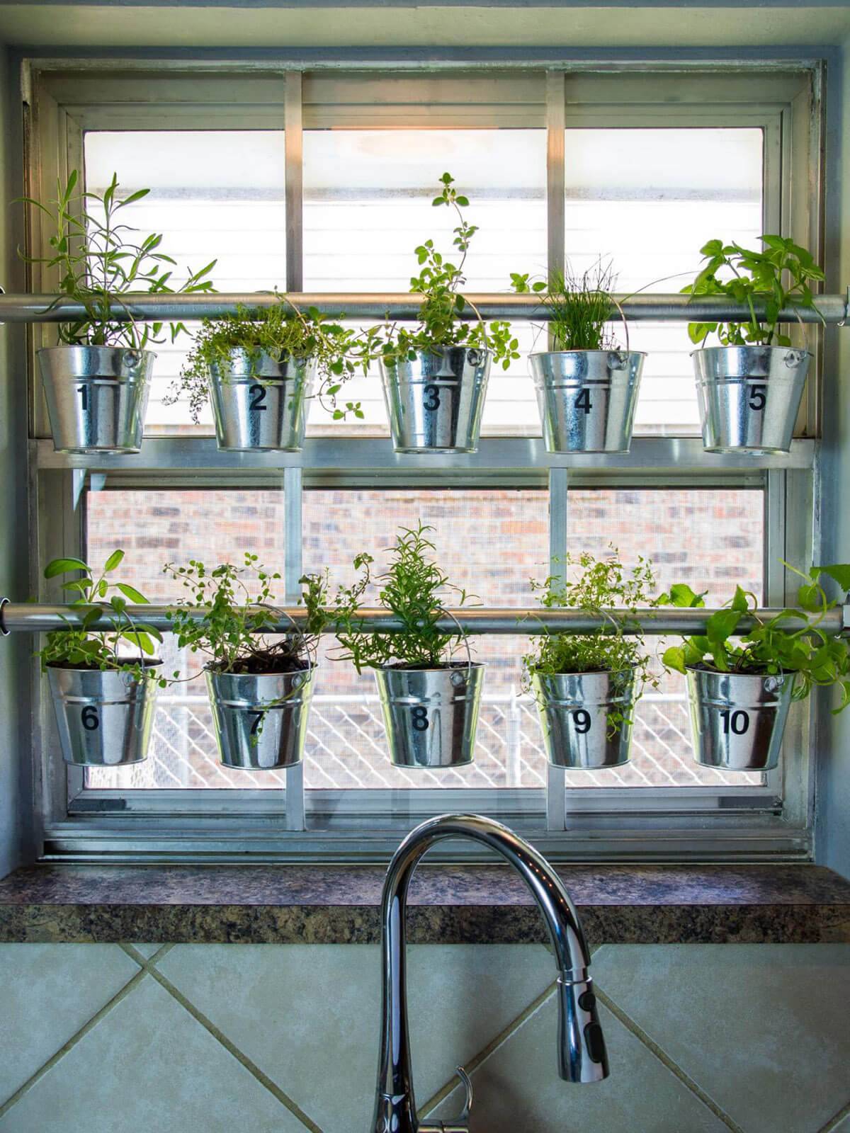 hanging herb garden in kitchen window in galvanized pots