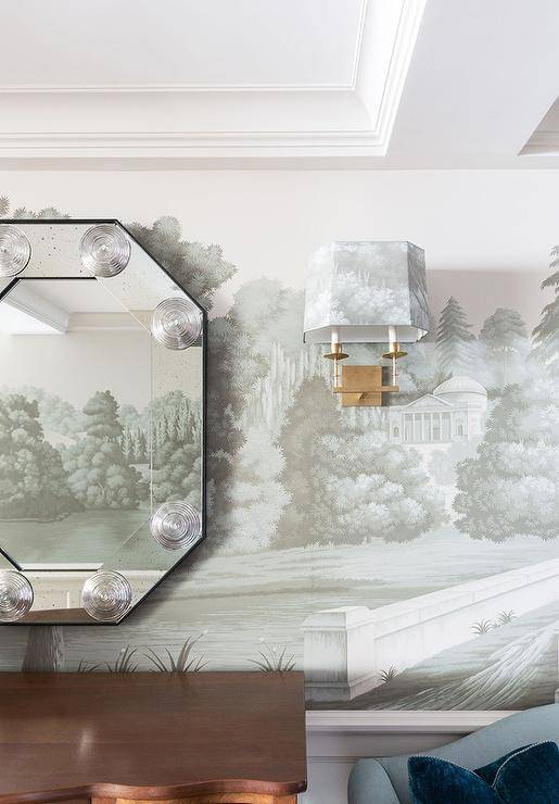Exquisite French hand painted wallpaper accents a living room showcasing a gorgeous octagon mirror.
