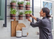 joanna gaines placing potted herbs on wall mounted kitchen rack