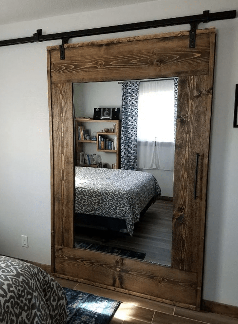 rustic barn wood frame door with mirror on wrought iron rails