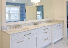 White double vanity with white marble countertop. Terrazzo flooring, double wide framed mirror with Global Views "Fortune Teller" sconce from Horchow.