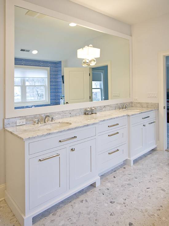 White double vanity with white marble countertop. Terrazzo flooring, double wide framed mirror with Global Views 