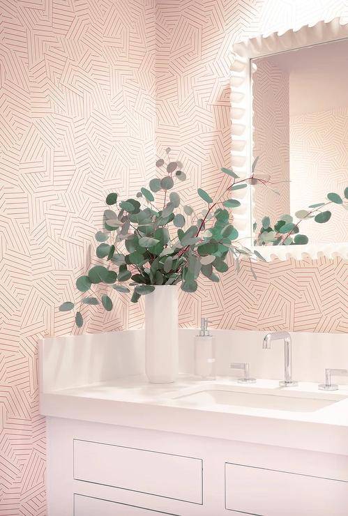 Contemporary powder room features Schumacher Deconstructed pink stripe wallpaper and white mirror over a white washstand.