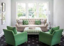 Charming beige and green living room is furnished with a beige tufted sofa topped with green pillows and placed on a black star pattern rug beneath a window. The sofa faces a green gingham ottoman seating two green accent chairs.