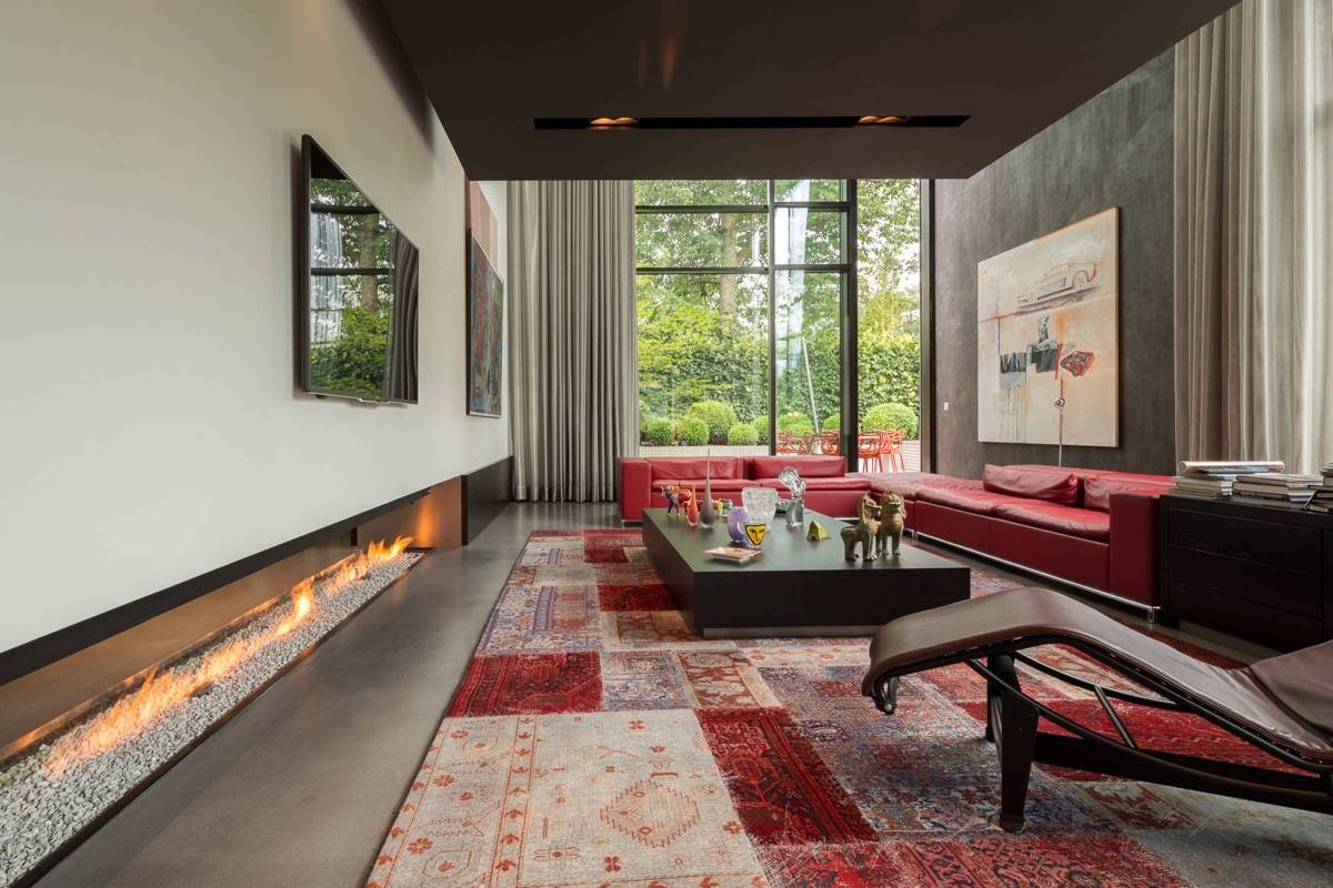 large modern living room with black and burgundy furniture low fireplace