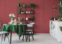 burgundy and green dining room with black chairs and open shelving
