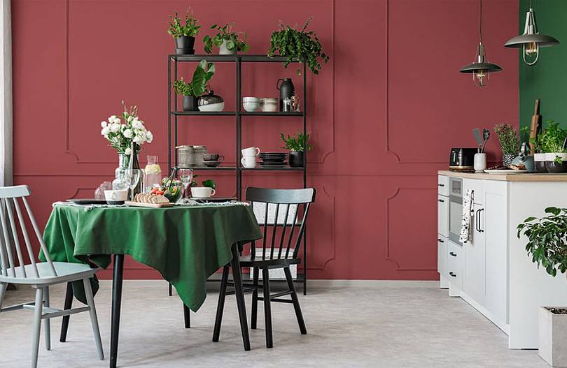 burgundy and green dining room with black chairs and open shelving