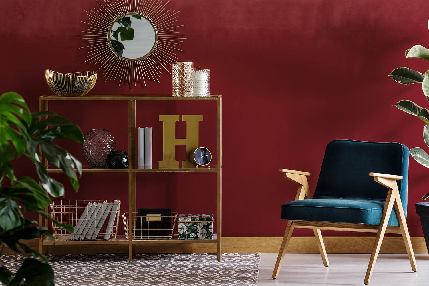 midcentury modern styled navy blue chair and shelf with gold accents and burgundy wall