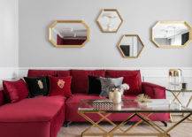 burgundy sectional couch with gold frame mirrors and gold legs coffee table