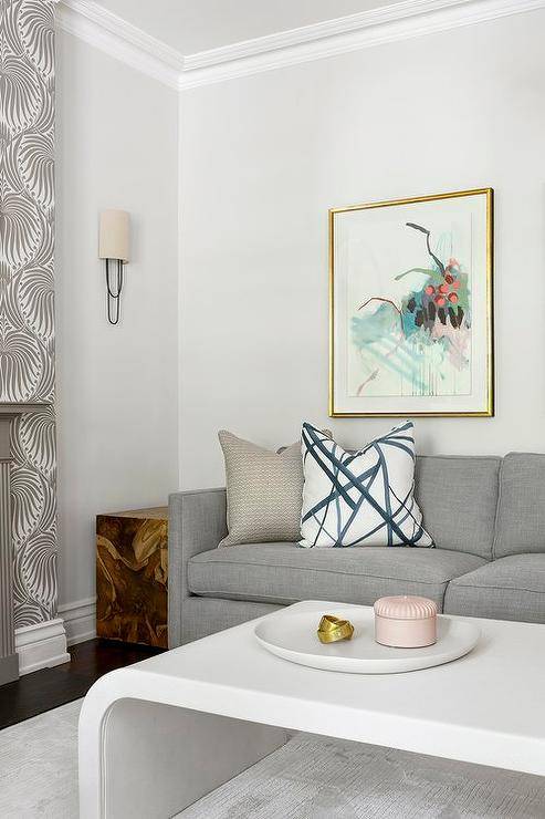 Living room features a gray couch with a white waterfall coffee table and a burl wood cube end table.