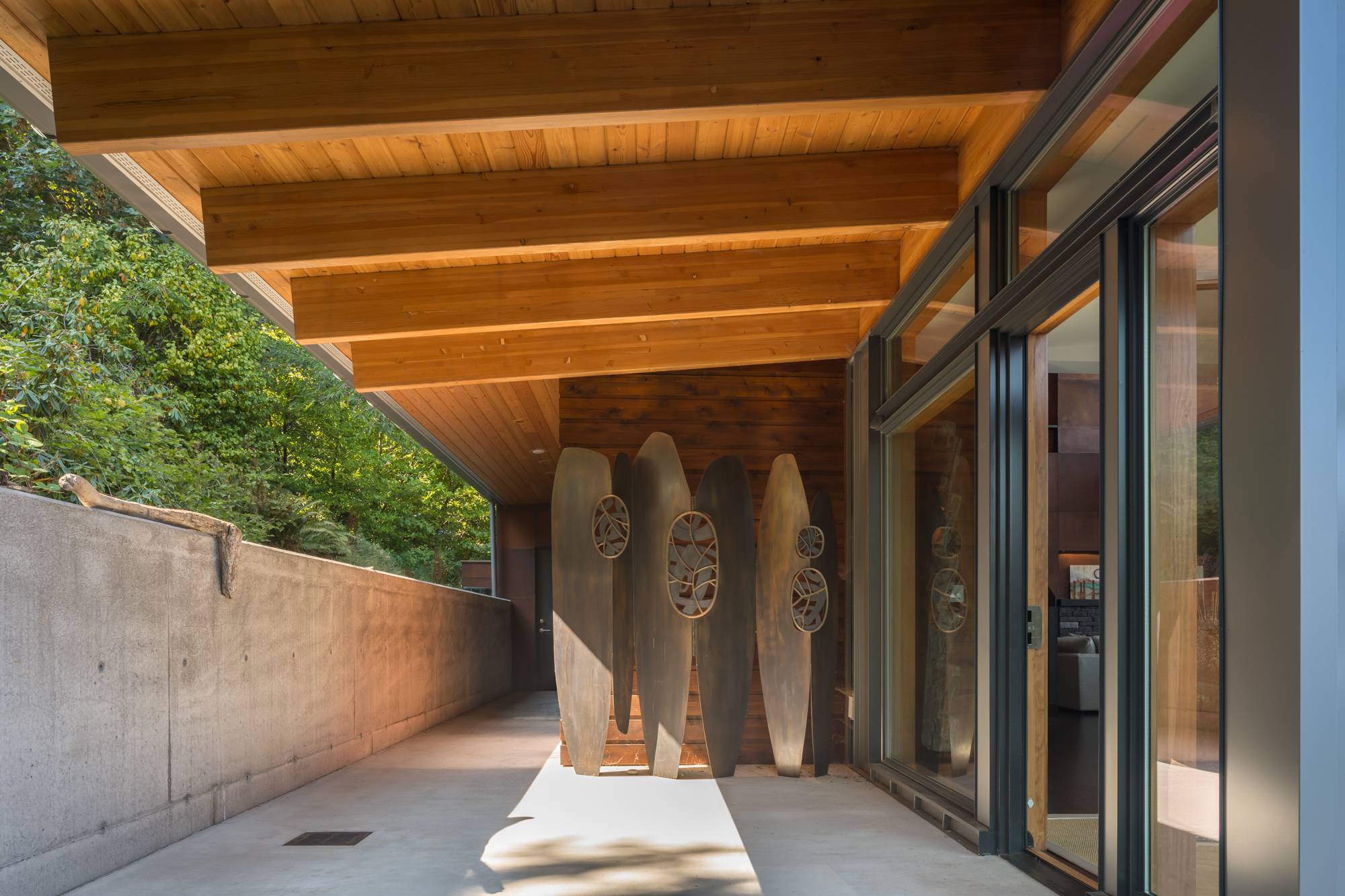 tall wooden sculptures leaning on wall of concrete entranceway