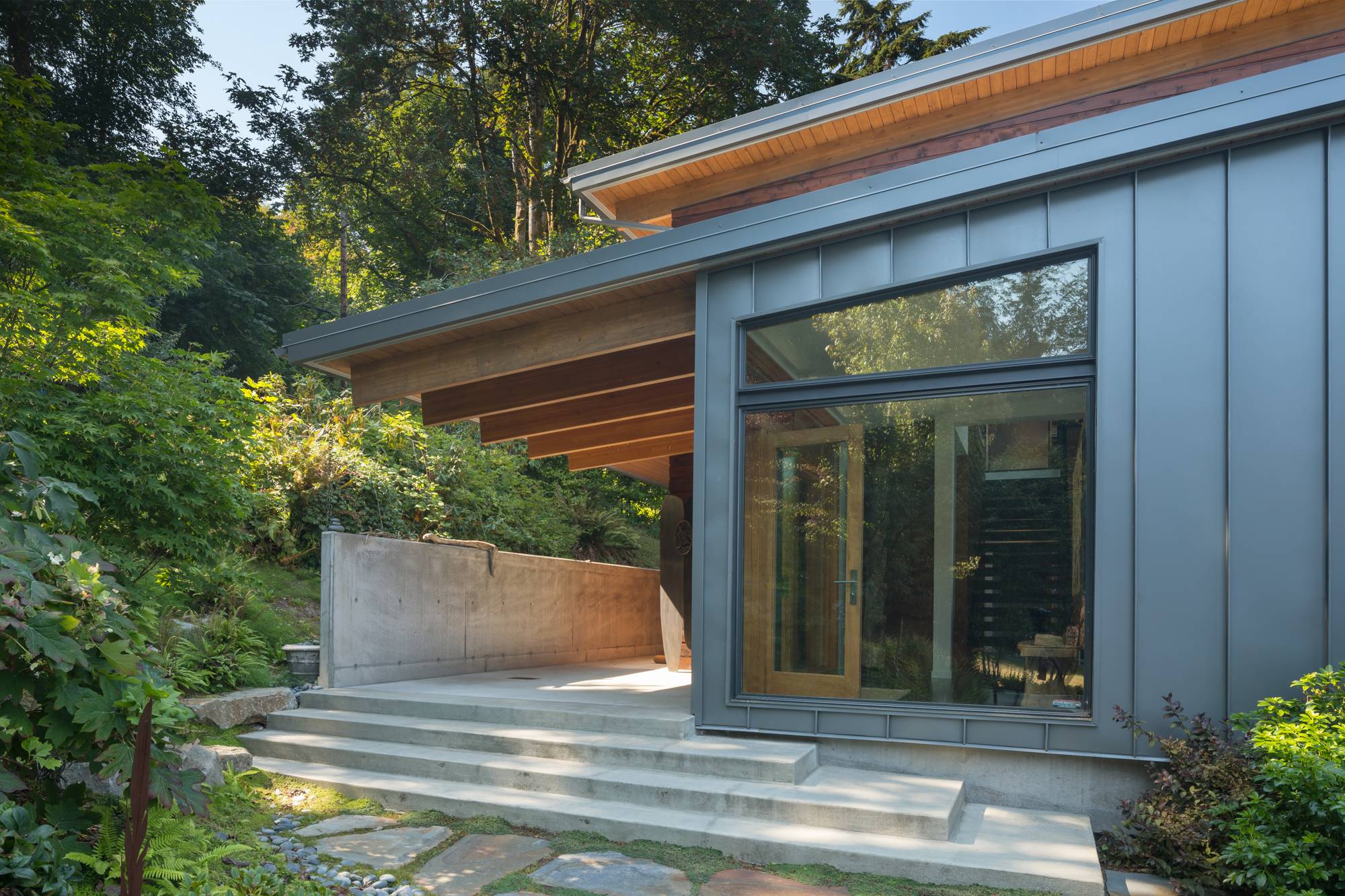 stone steps up to entryway of metal framed home