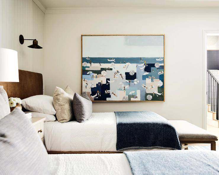 A large waterfront painting hangs in a welcoming shared cottage bedroom.