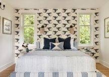 Bedroom features a low wingback blue stripe headboard with blue and white bedding and black and white Mr. Blowfish Wallpaper.