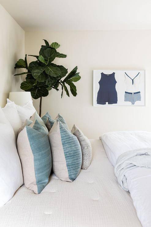 Bedroom features vintage swimsuit art and a bed with blue and cream bedding.